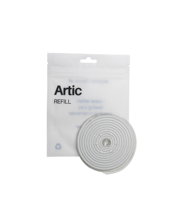 A white Artic refill packet stands upright behind a coiled, round white refill insert displayed in front of it on a plain white background.