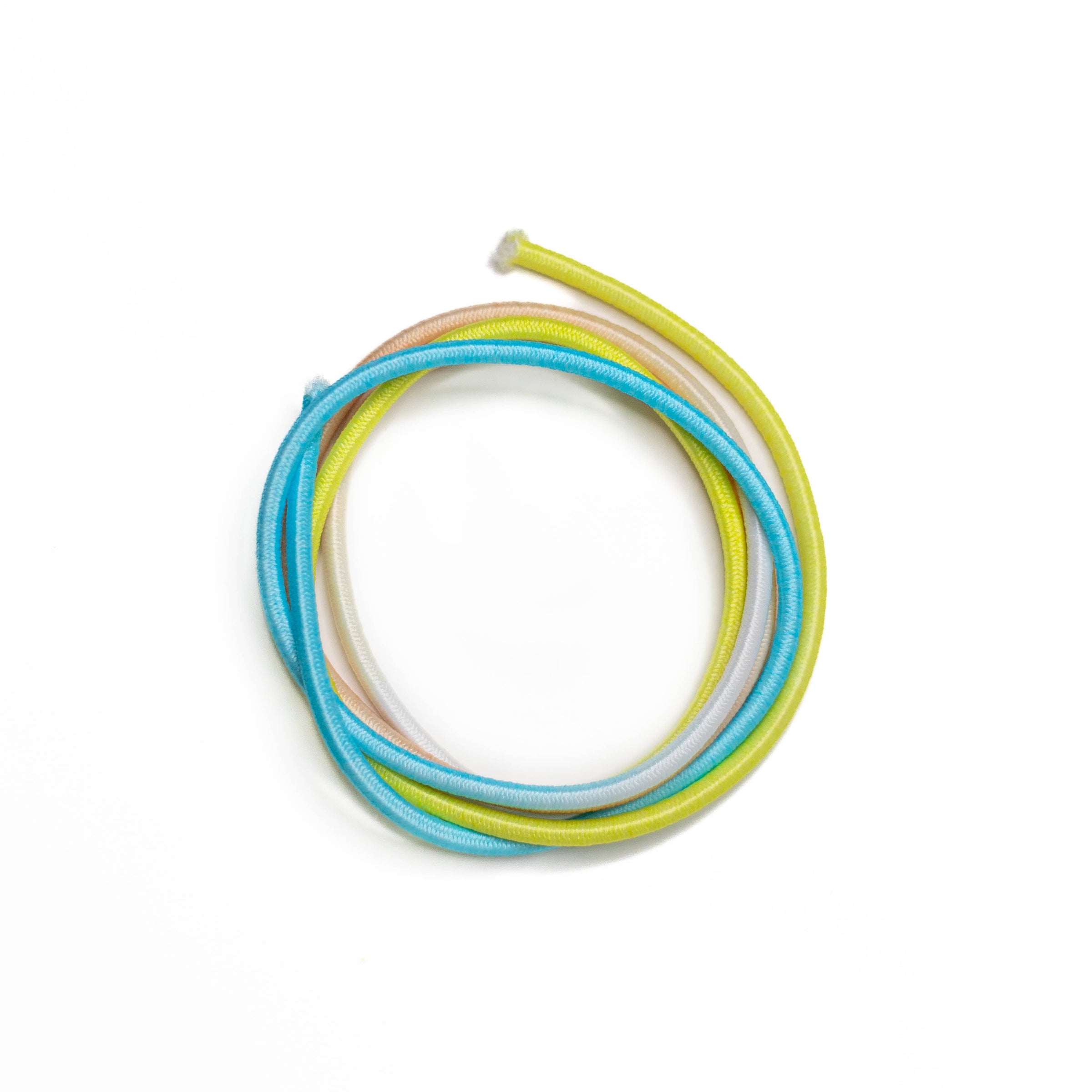 Three colorful hair ties‚Äîblue, yellow, and light pink‚Äîare placed in a circular arrangement on a white background.